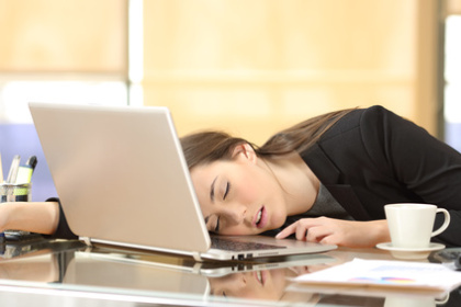 Fernstudentin kann sich nicht konzentrieren und schläft auf Laptop ein